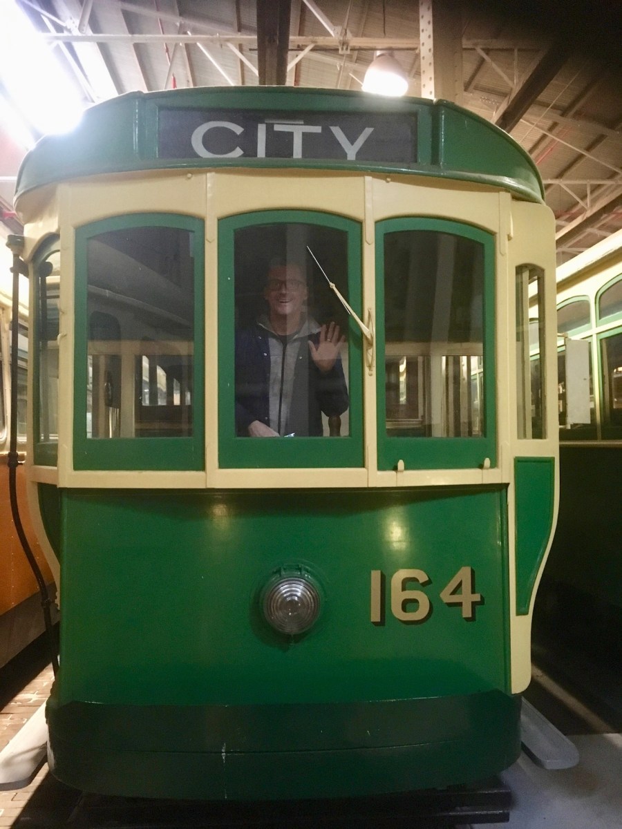 Man waving from drivers window of city tram at the Tram Museum, Hawthorn