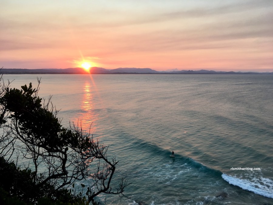 A surfer on a wave at sunset, Byron Bay, NSW