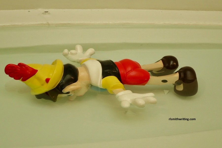 Pinnochio floating face down in water at the Guggeheim New York